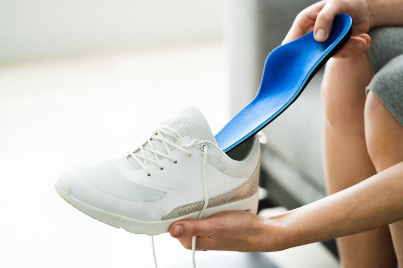 Person placing a custom orthotic into their shoe