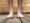 Pair of feet on a wood surface showing a heel spur on one foot