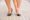 Woman in short heels experiencing bunions, one of the most common foot problems in women