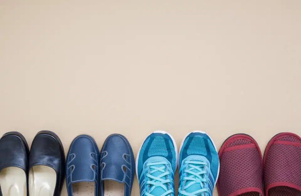 four different pairs of shoes lined up in front of beige background