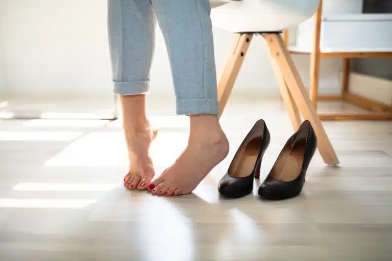 Woman with her heels next to her feet