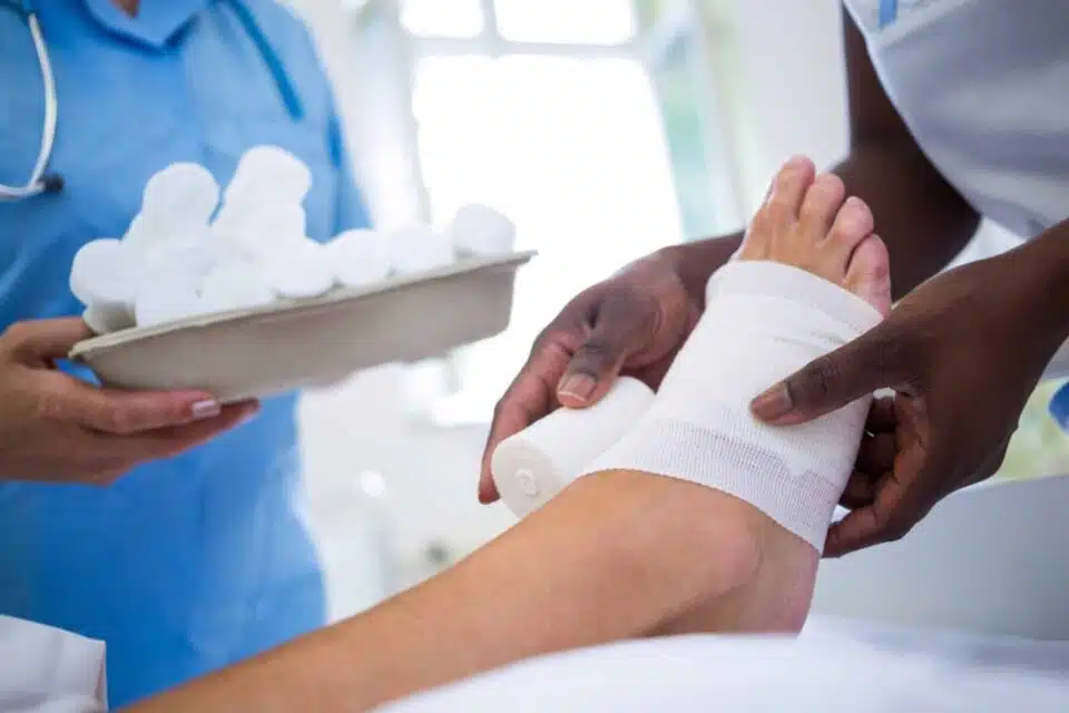 Medical professional wrapping a diabetic patient's foot for an open wound and ulcer