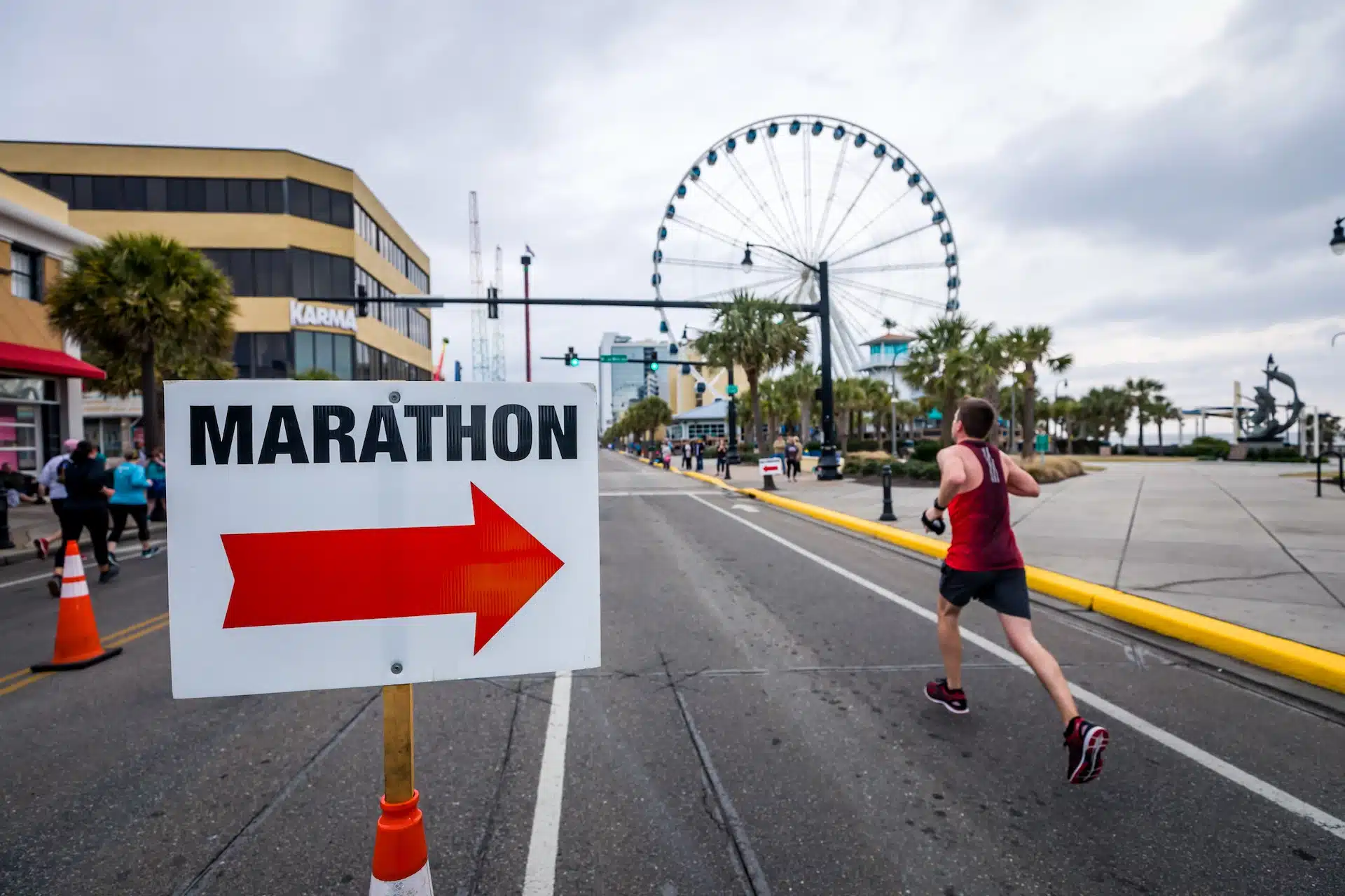 A runner running past a sign that says marathon