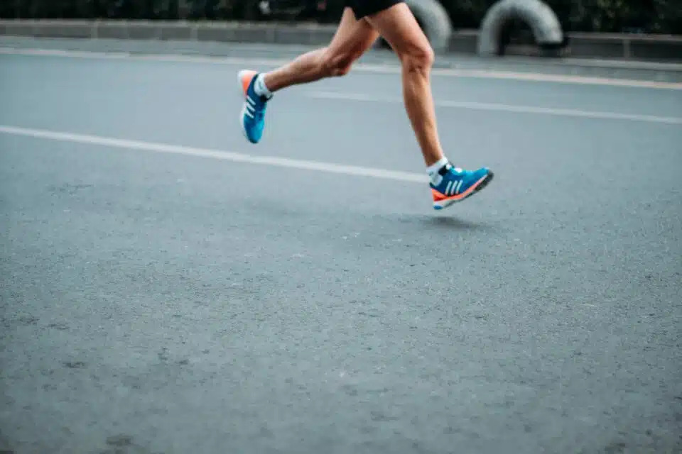A close-up photo of a runner and their legs and shoes