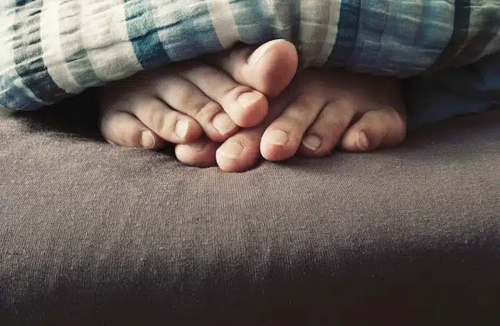 Toes underneath a blanket