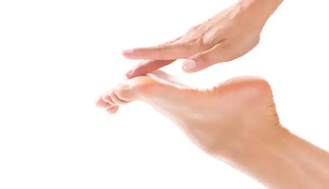 Close up of woman touching ball of the foot