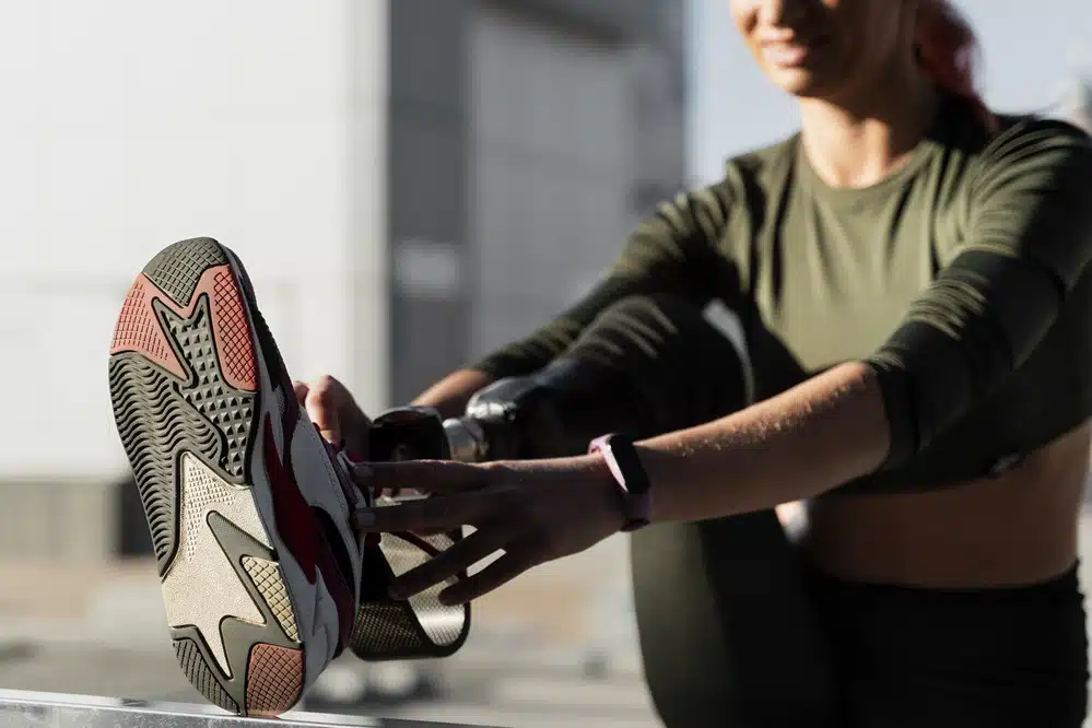 Woman putting running shoe on foot