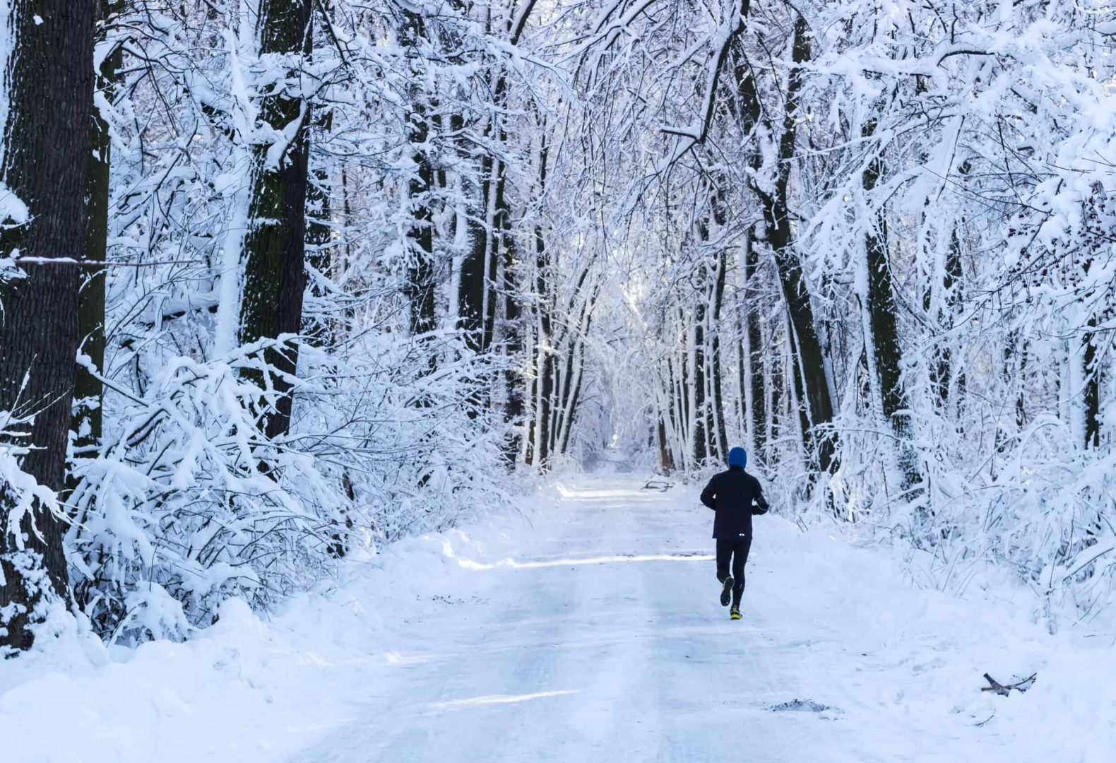 Man running in the forest in winter time