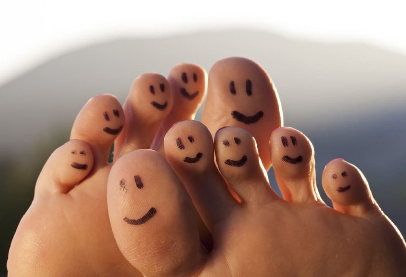 Smiley faces drawn on the bottom of toes