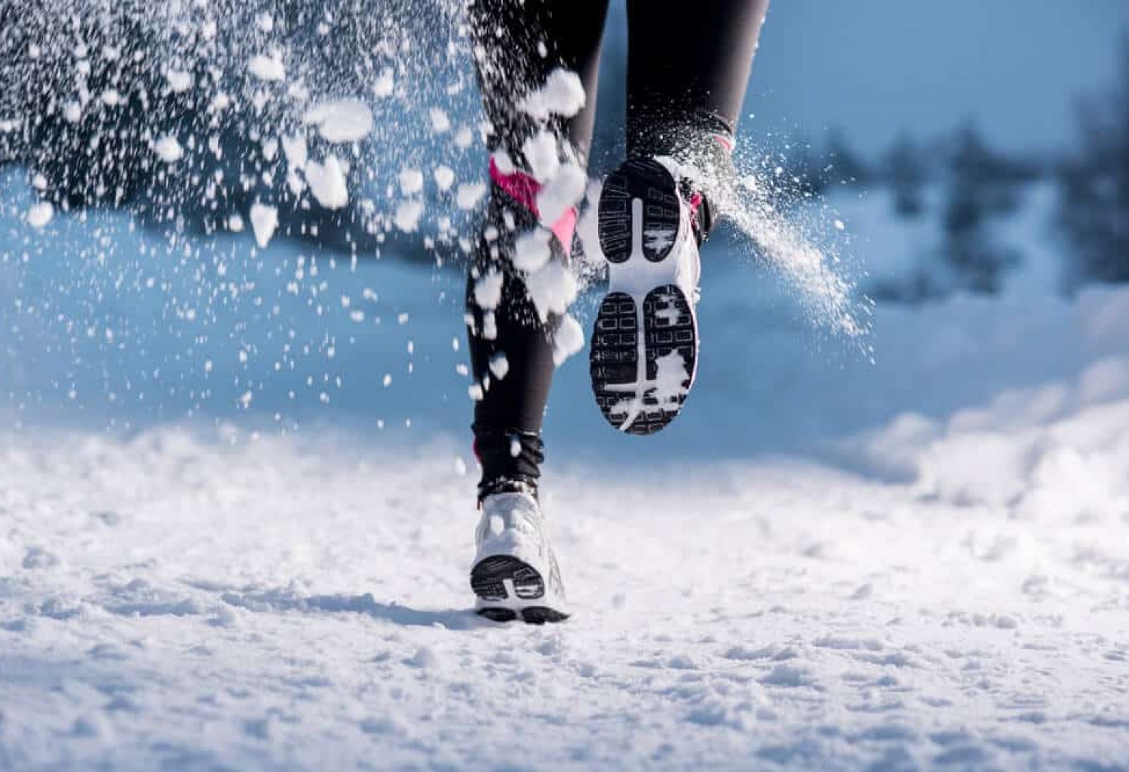 person running on winter trail one foot lifted in motion