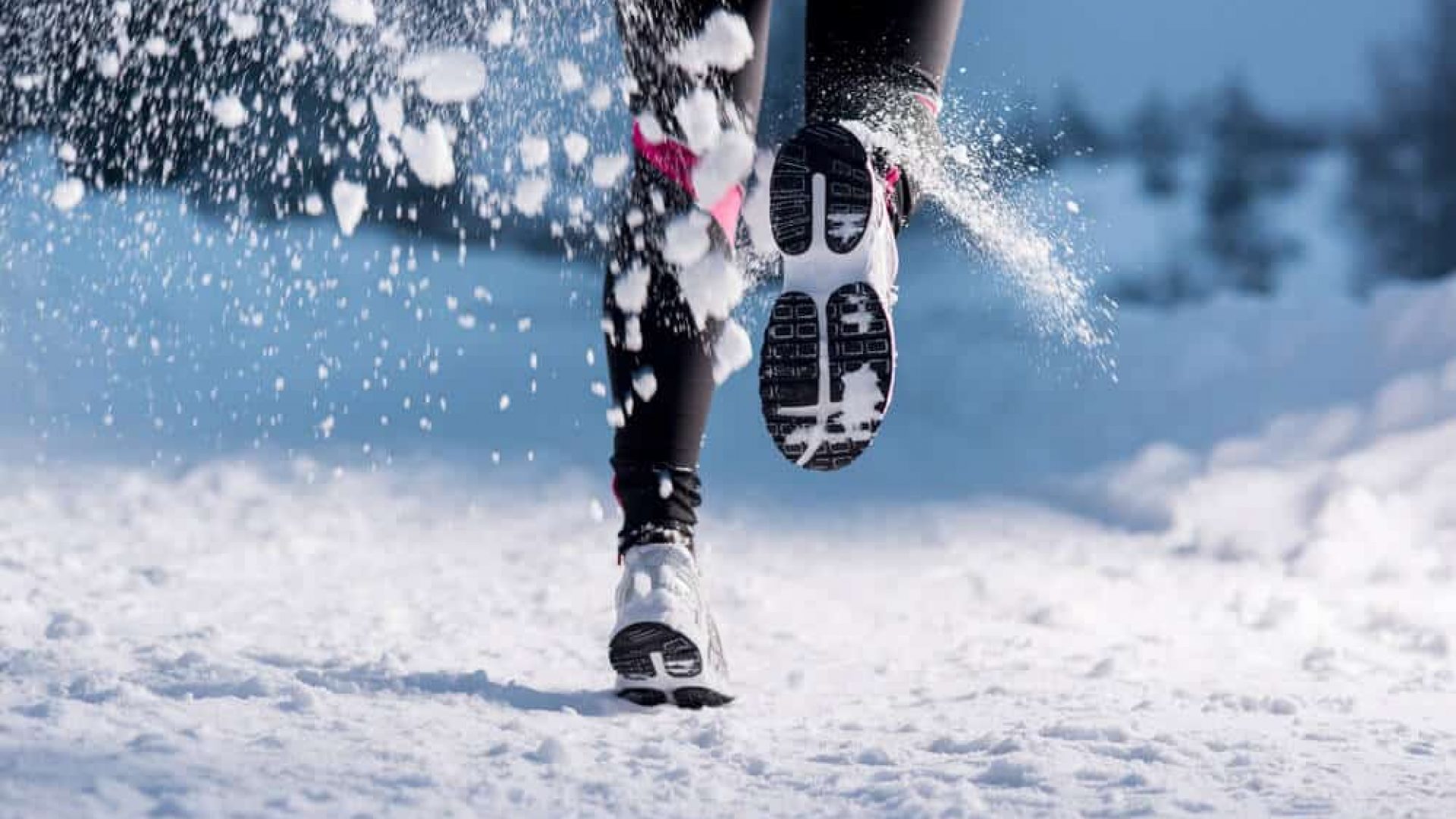 person running on winter trail one foot lifted in motion