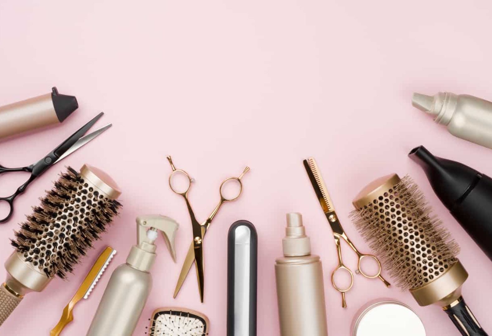 Various hair dresser tools on pink background with copy space