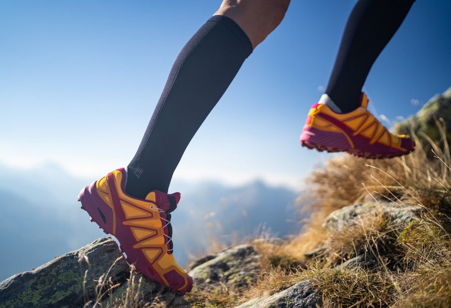 Athlete propelling up a mountain with running shoes and long stockings