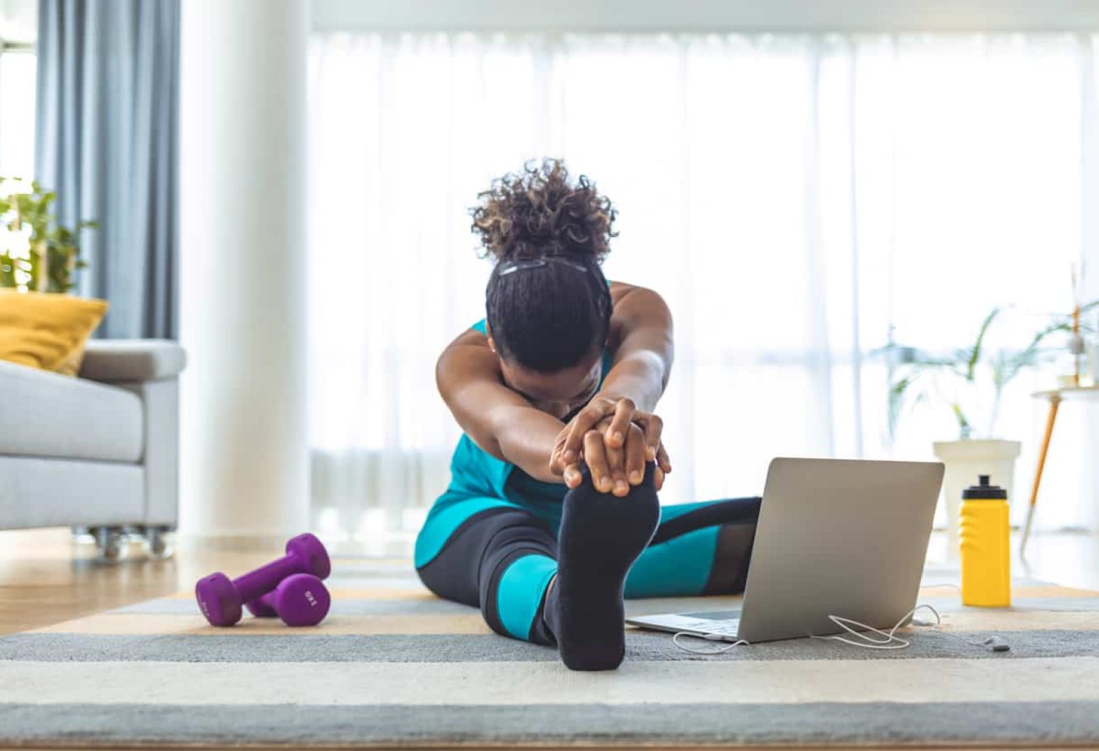 Fit woman high body flexibility stretching her leg and back to warm up doing aerobics gymnastics exercises at home.