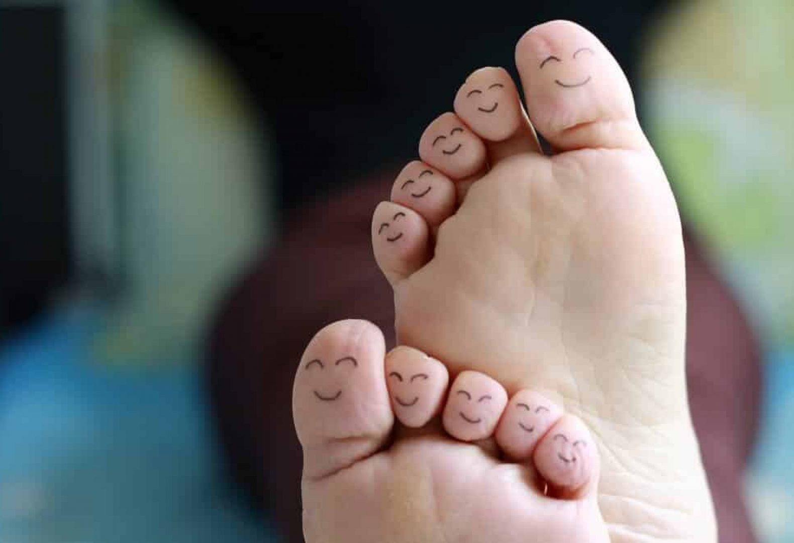 close up of ten toes with smiley faces on them