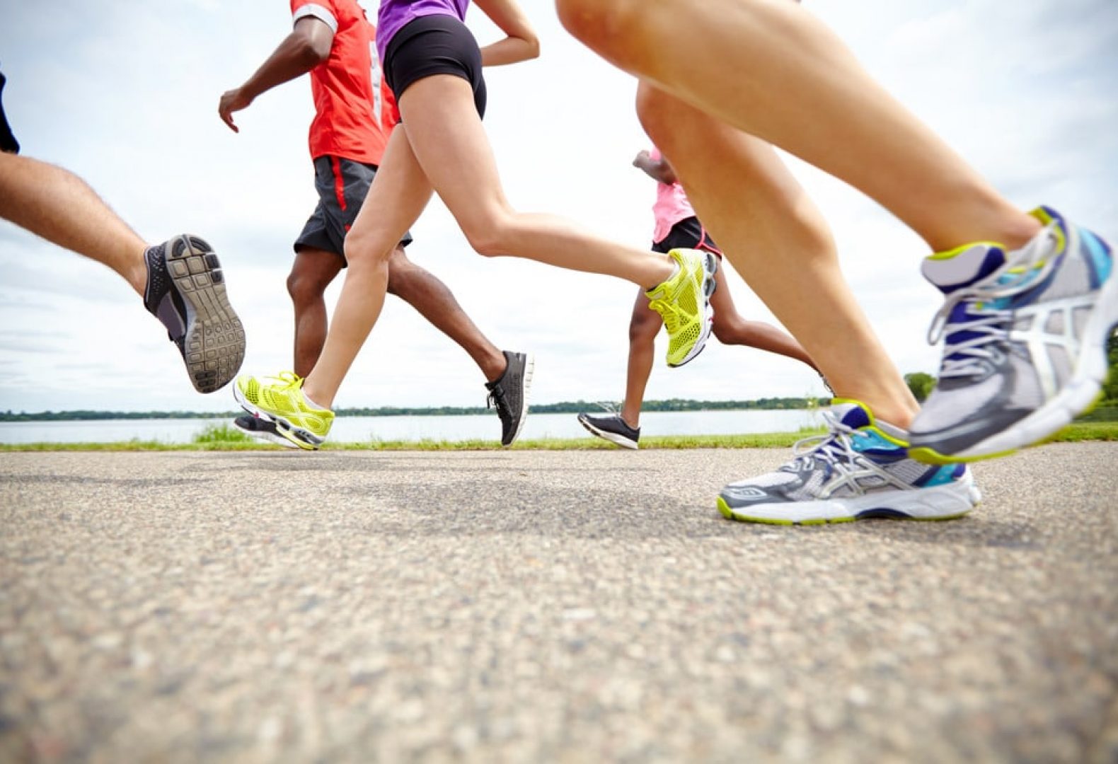 close up of feet and legs of a group of runners wearing different running shoes