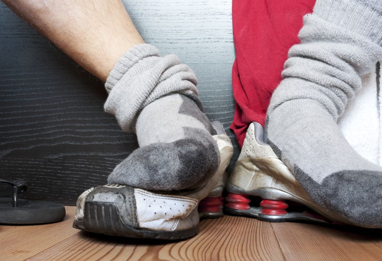 Close-up view of sweaty socks after workout over a pair of worn out dirty shoes.