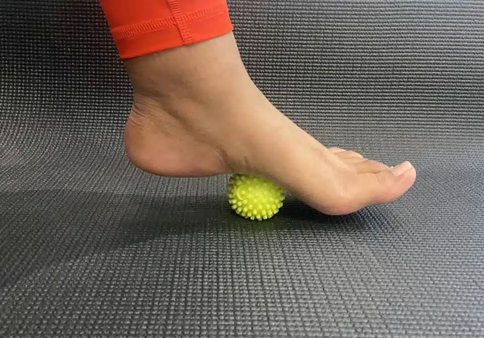 A foot rolling a massage ball to relieve foot pain