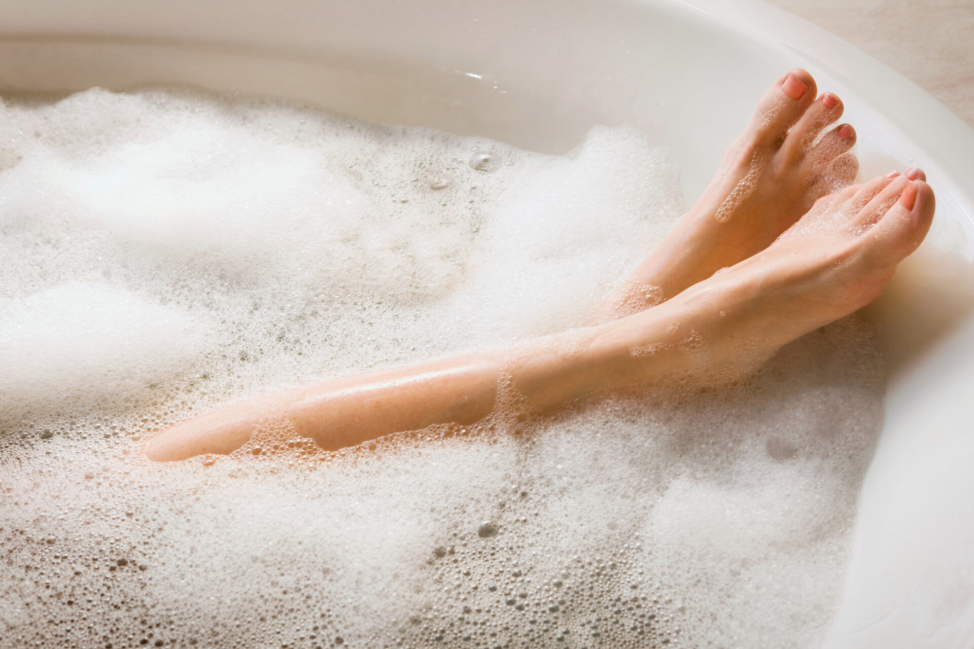 Close up of feet soaking in a warm bath