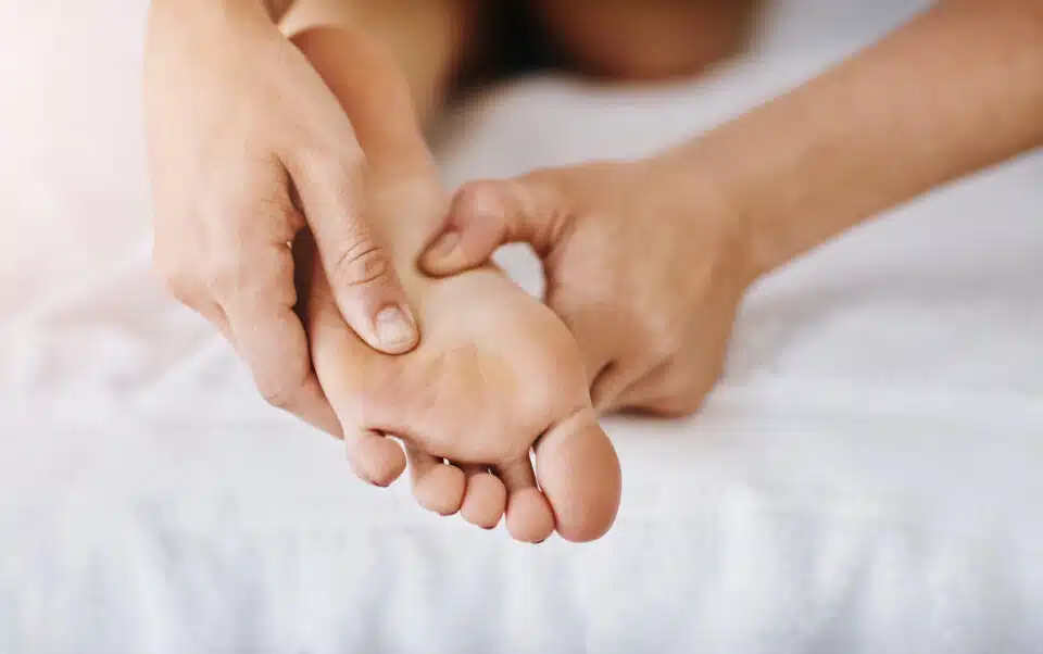 performing foot massage technique between foot's arch and ball of the foot