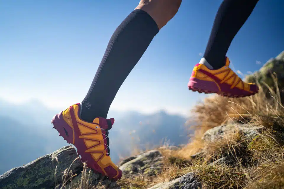 Athlete propelling up a mountain with running shoes and long stockings