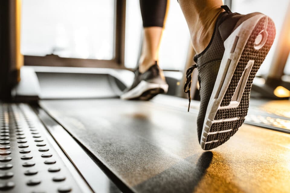 Close up of a person wearing running shoes on the treadmill