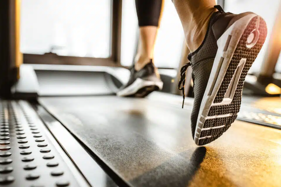 Close up of a person wearing running shoes on the treadmill
