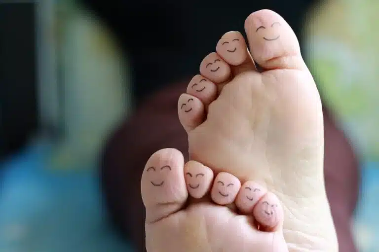 close up of ten toes with smiley faces on them