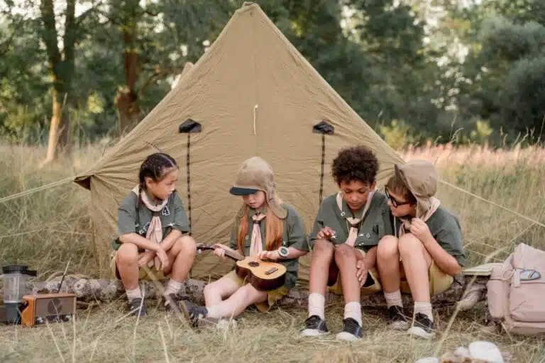 Kids at summer camp sitting outside their tent