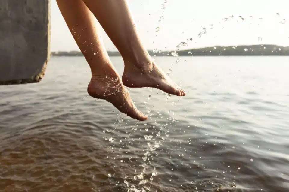 Woman splashing her feet in the water during summer